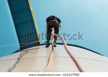 Male worker rope access  inspection photo from the bottom of the fuel tank's.