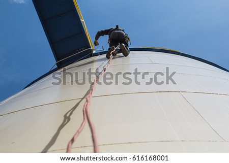 Male worker rope access  inspection photo from the bottom of the fuel tank's.
