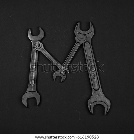 Letter M. Alphabet made of repair tools. Creative black and white font