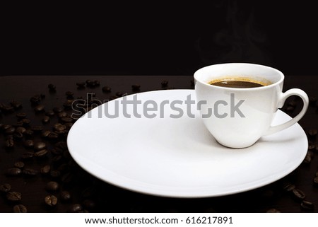 warm cup of coffee on brown background with many coffee beans around