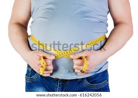The belly of a fat man isolated on white background. Fat man holding a measuring tape. Weight Loss. Royalty-Free Stock Photo #616242056
