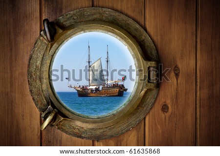 Close-up of a boat closed porthole with view to an old galleon