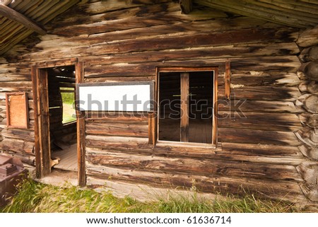 Ruin of old cabin with empty sign providing copyspace for your message