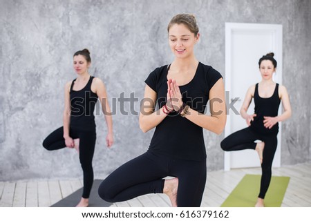 Smiling yogi girl in class in Yoga asana, exercising, stretching