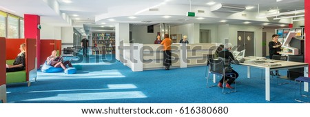 Panorama of modern and spacious university library with blue carpet on the floor