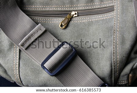 closeup of buckles, clasps, zippers, pockets, fasteners, fittings and seams on the hand bag of coarse cotton fabric