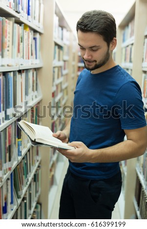 Handsome man in early 20s spending his time in library. University time 