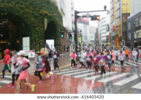 blurred photo of woman runners join the woman marathon in Tokyo under the rain 