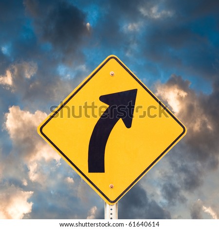 Road sign warning of dangerous curve with dramatic sky background.