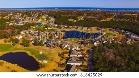 Beautiful aerial view of a private community golf course with the beach on the horizon.