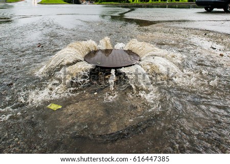Accident sewerage system. Water flows over the road from the sewer. 
 Royalty-Free Stock Photo #616447385