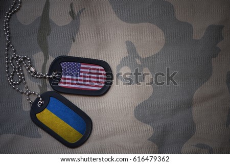 army blank, dog tag with flag of united states of america and ukraine on the khaki texture background. military concept