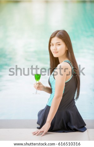 Beautiful woman wearing swimming wear looking to camera at border of swimming pool