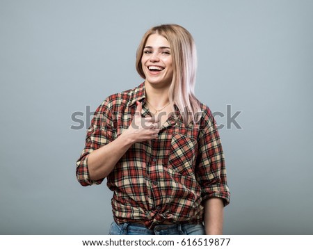 Attractive young girl with thumb up on grey