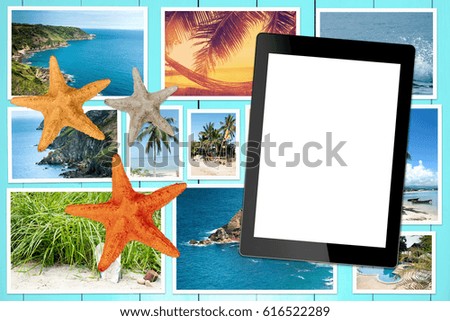 Tablet with blank screen and holiday photos on a wooden table. View from above and lie flat.