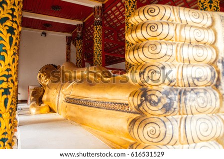 Reclining golden Buddha statue with thai art architecture in temple