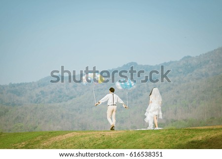 Wedding couple together walking in nature on the lawn  . Wedding photography with unrecognizable groom and bride.