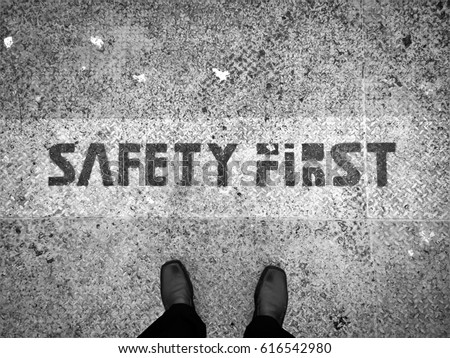 Man stand on rusty grunge metal floor with safety first word as concept background - Black and White