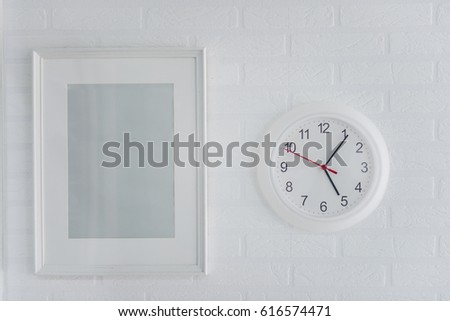 White modern picture frame white and modern analog clock on a brick wall background