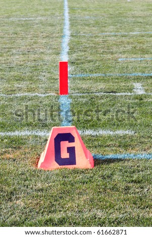 Color DSLR picture of the goal line on an American sports football field.  Crossing this line scores a touchdown and is the objective of game. Vertical orientation with copy space for text