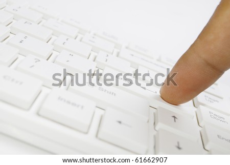 Finger on white computer keyboard