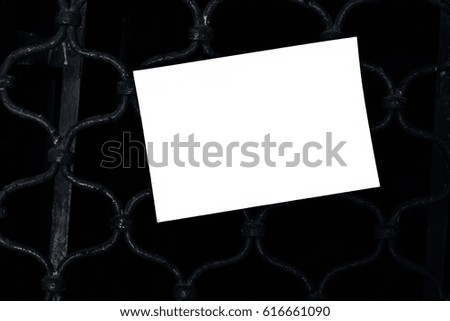A white blank paper hanging in a wall.