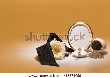 white urn with blank mourning frame, white rose, black tape, and rosary for sympathy card on yellow background