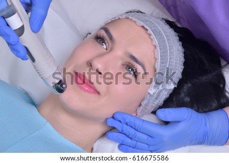 Young beautiful woman gets professional facial skin treatment in a professional beauty clinic
