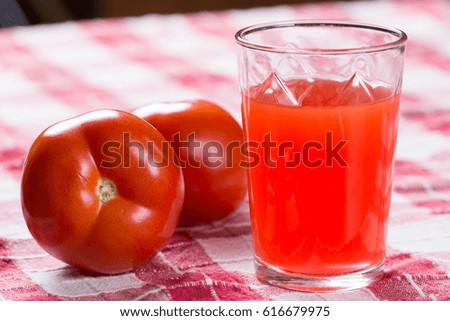 Tomato juice on the table with fresh raw tomatos.