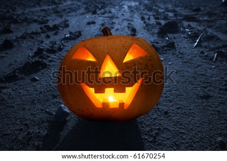 Halloween glowing and smiling pumpkin face on dark land with moonlight at night