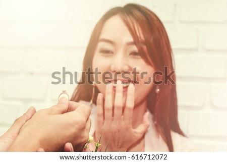 A man giving diamond ring to beautiful woman to ask her merriage.
