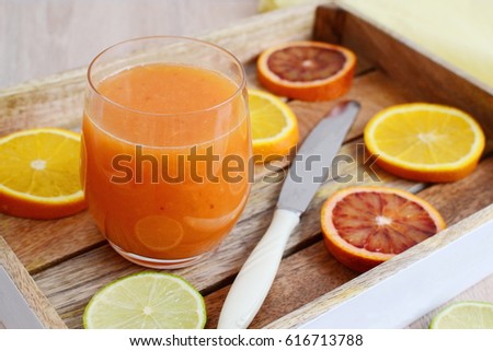 Orange juice in glass and fresh fruits on wooden background, vitamin drink