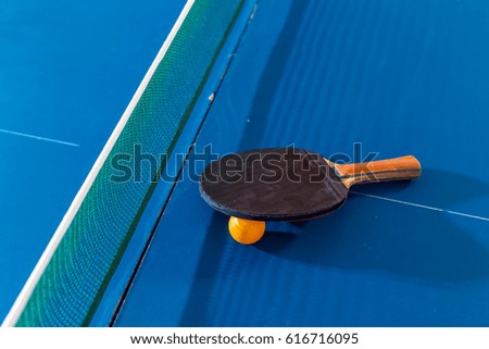 Table tennis bats and ball on a table with white vertical line. Concept of competition. Table tennis bat and ball on table, with space
