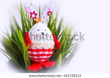 Funny Easter egg bunny rabbit decorations in green grass postcard holiday background