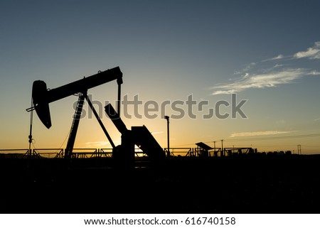 Silhouette of Bpu crude oil pump in the oilfield at sunset 