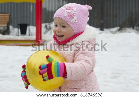 The little girl plays on the playground in the spring