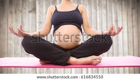 Digital composite of Pregnant woman meditating against blurry wood panel