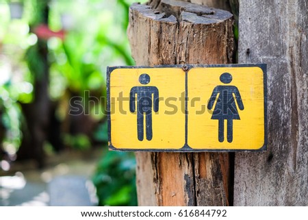 Toilet Sign (man and woman) draw on yellow sign wood for background or texture.