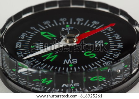 round magnetic compass with bright symbols lies on the table