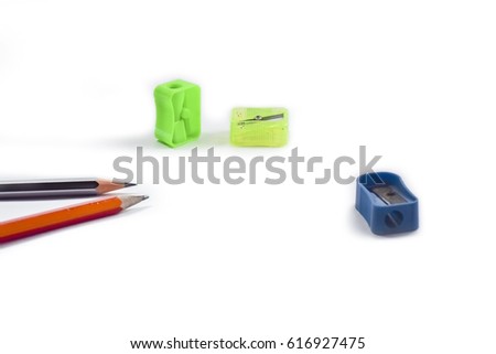 Back to school concept- a Pencil,eraser, sharpener an cut slice of the pencil on white table with or without spectacles not properly arranged isolated.