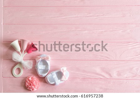 Newborn baby girl background. Newborn accessories for a baby girl on a pink wooden background.