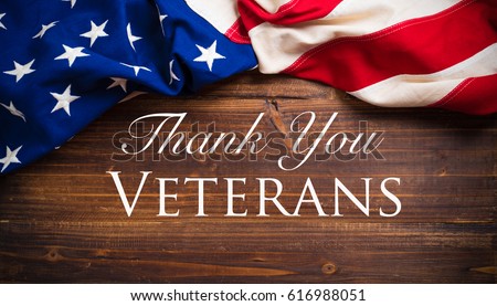 An old american flag on a antique wooden platform - Veterans Day Royalty-Free Stock Photo #616988051