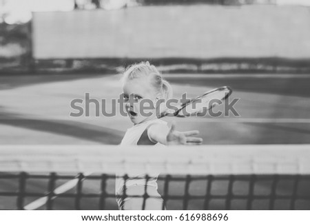 black and white picture of the little girl playing tennis