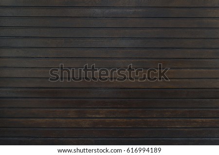 Old dark brown wooden fence background texture close up