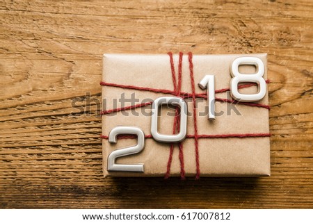silver metal numbers forming the number 2018, For the new year 2018 on rustic wooden with gift box and red ribbon. empty copy space for inscription or objects