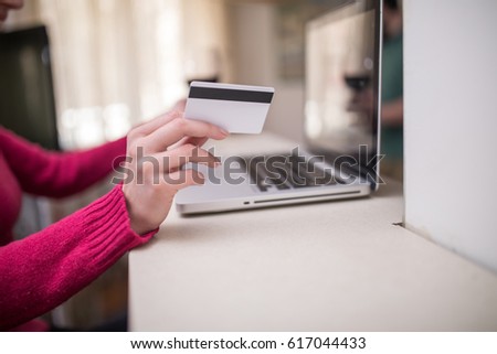 Cropped photo of a woman holding credit card and shopping online on laptop