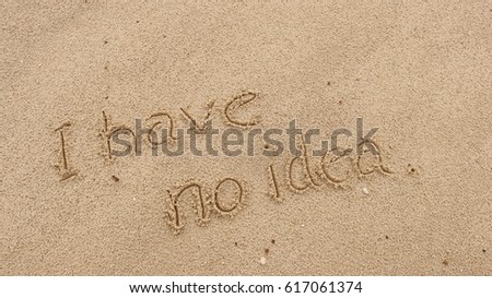 Handwriting  words "I have no idea" on sand of beach.