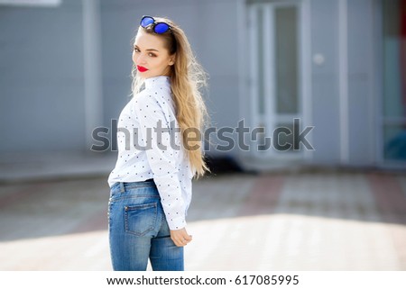 Young beautiful woman, cheerful and emotional, smiling and dancing on the street