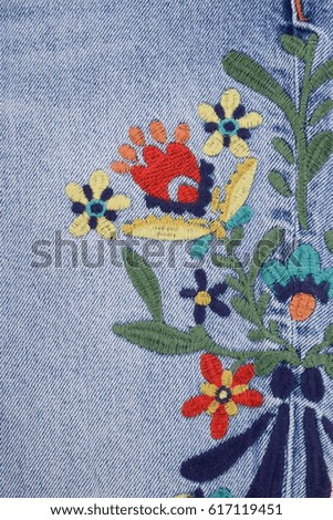 embroidered, flowers on female,blue jeans texture

