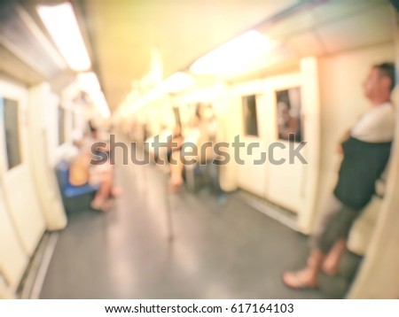 blurred image of people sitting and standing in the electric train.